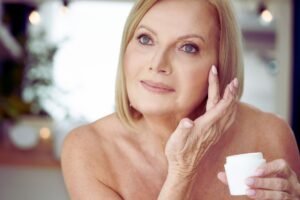 Femme appliquant de la crème sur son visage.