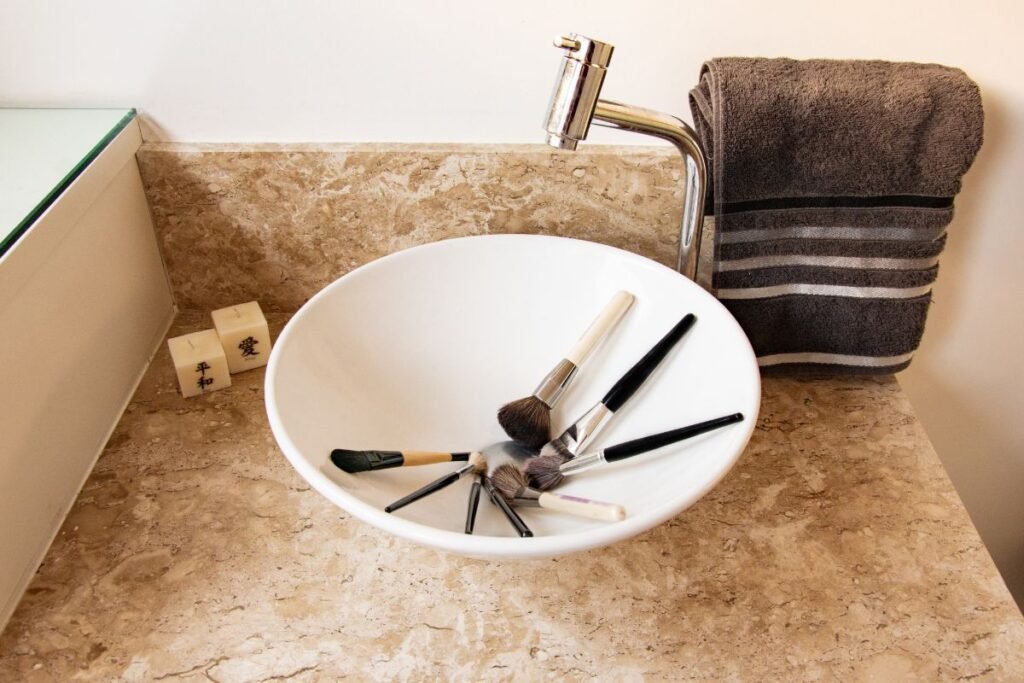Pinceaux de maquillage dans un lavabo prêt à être nettoyés